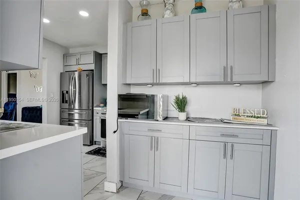 a kitchen with white cabinets and stainless steel appliances
