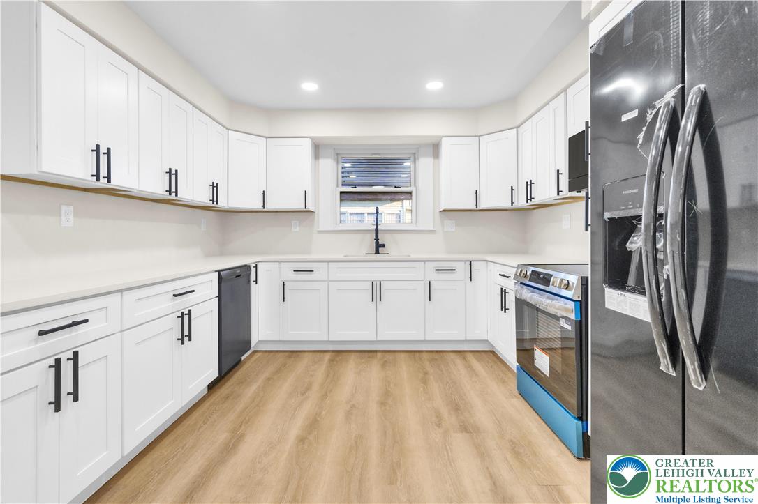 416 Main Street Stockertown, PA 18083 - Photo 5 of 29 a kitchen with stainless steel appliances granite countertop a sink a stove a refrigerator and white cabinets