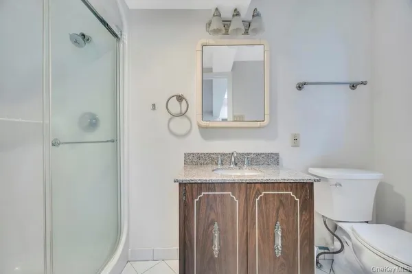 a bathroom with a granite countertop sink a mirror and a shower