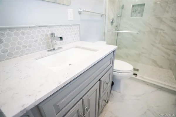 a bathroom with a sink a toilet and shower