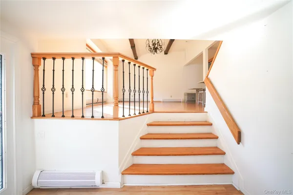 a view of a bedroom with wooden floor and a rug