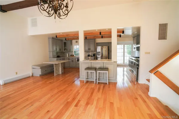 a dining room with wooden floor and stainless steel appliances