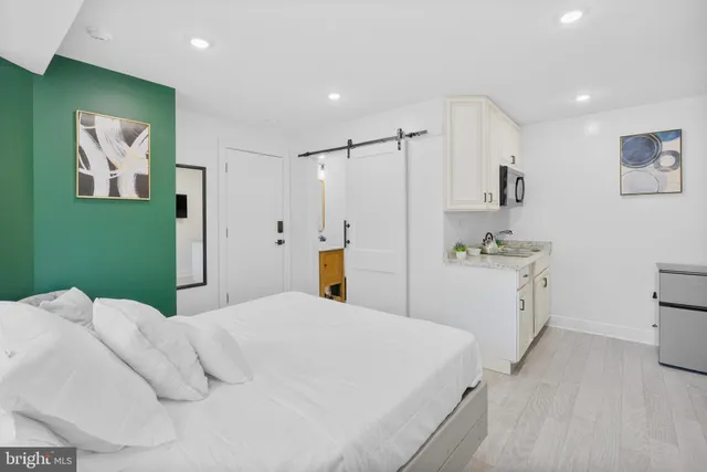 a bedroom with a bed and a refrigerator