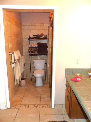 a bathroom with a granite countertop toilet and a sink