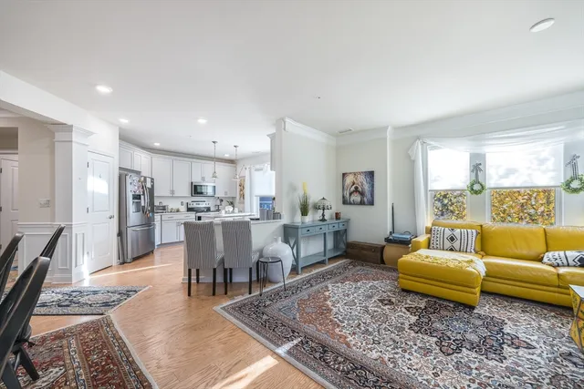 a living room with furniture wooden floor and a dining table