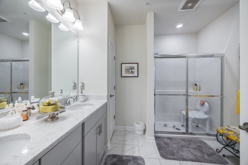 4 Francis Drive, Unit 207 Andover, MA 01810 - Photo 11 of 21 a bathroom with a double vanity sink a mirror and a shower