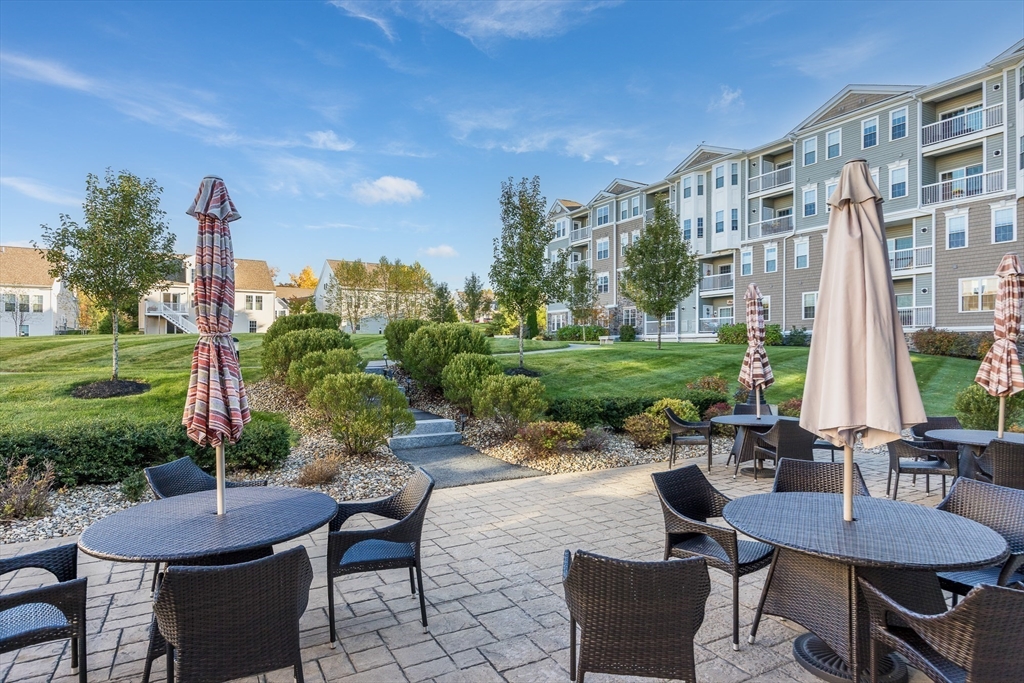4 Francis Drive, Unit 207 Andover, MA 01810 - Photo 19 of 21 a view of a patio with couches table and chairs with plants and trees