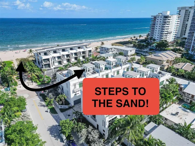 an aerial view of residential houses with outdoor space and parking