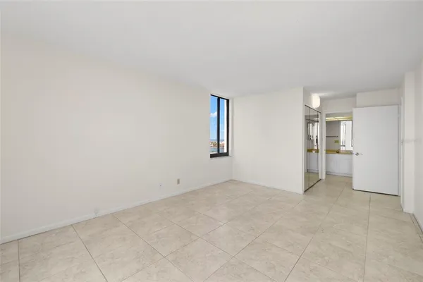 a view of an empty room with a balcony and large windows