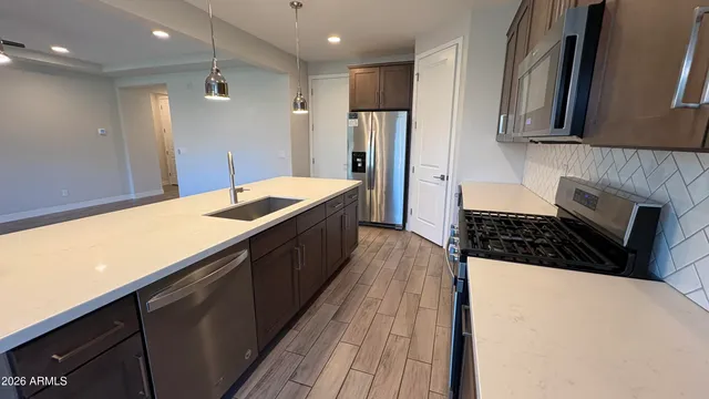 a kitchen with granite countertop a sink a stove and refrigerator