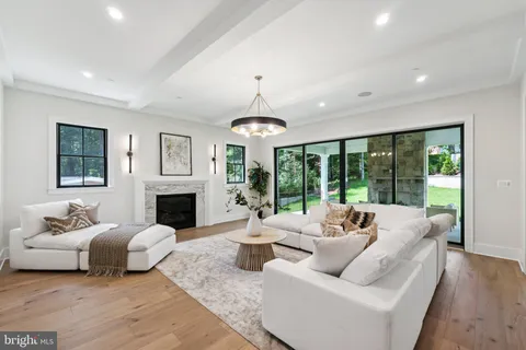a living room with furniture a fireplace and a chandelier