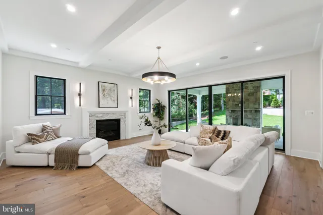 a living room with furniture a fireplace and a chandelier