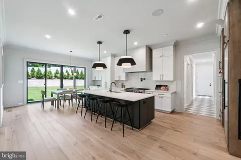 a kitchen with a table chairs stove and wooden floor