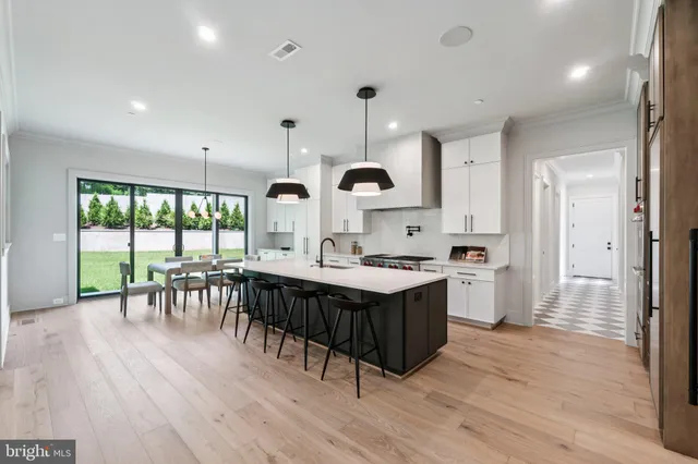 a kitchen with a table chairs stove and wooden floor