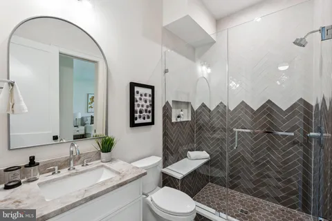a bathroom with a sink vanity mirror and toilet