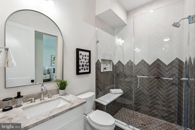 a bathroom with a sink vanity mirror and toilet