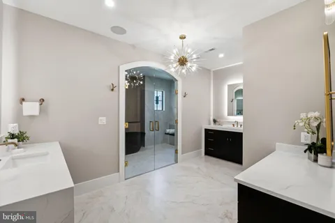 a spacious bathroom with a sink double vanity granite and a shower