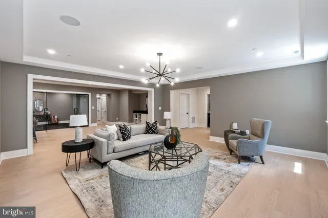 a living room with furniture a fireplace and a chandelier