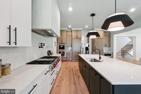 a kitchen with stainless steel appliances a sink a stove and a wooden floors