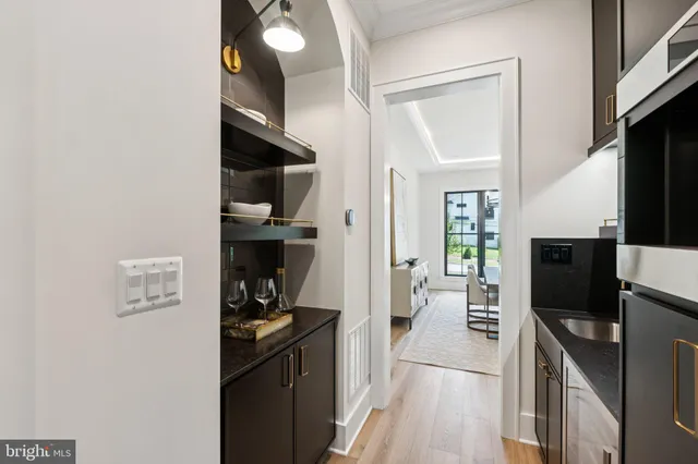 a kitchen with a refrigerator wooden floor and a stove top oven