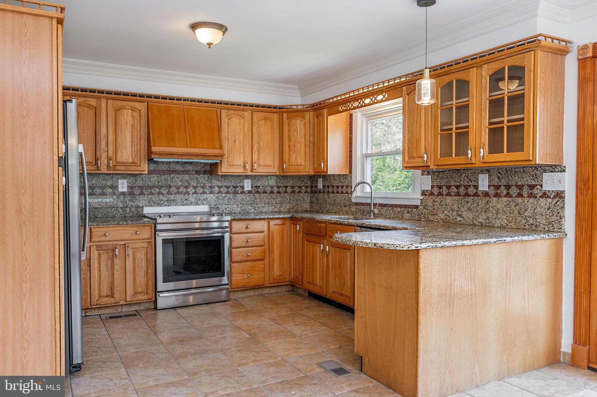 11325 Bacon Race Road Woodbridge, VA 22192 - Photo 12 of 54 a kitchen with stainless steel appliances granite countertop a stove sink and cabinets