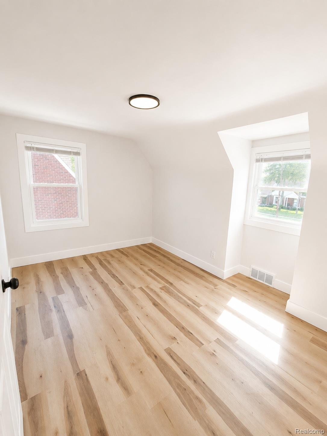 20024 Meyers Road Detroit, MI 48235 - Photo 11 of 16 Bright room featuring wood-finish flooring, white baseboards, and two windows with white trim