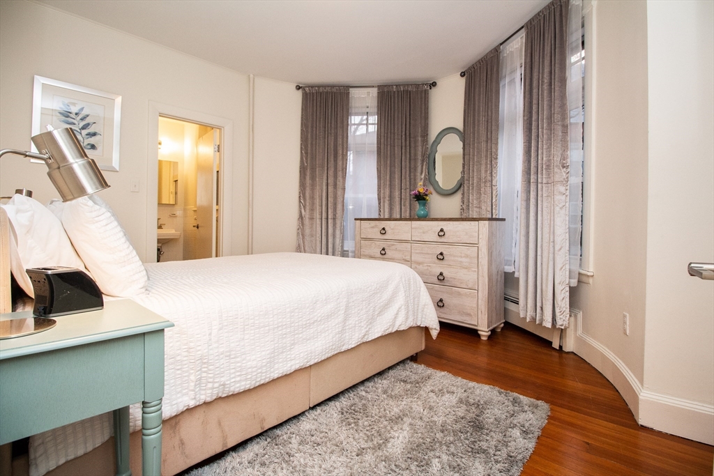 1871 Beacon Street, Unit 3 Brookline, MA 02445 - Photo 10 of 14 a bedroom with a bed and a flat tv screen on the dresser