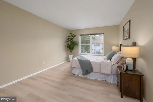 a spacious bedroom with a bed and wooden floor