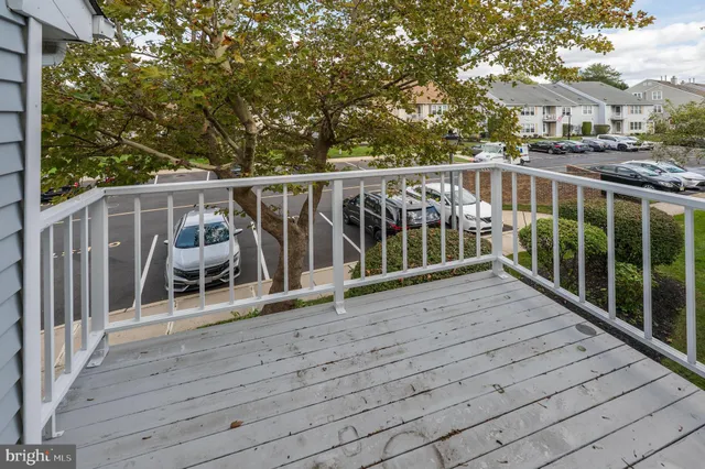 a view of a balcony with wooden floor and fence