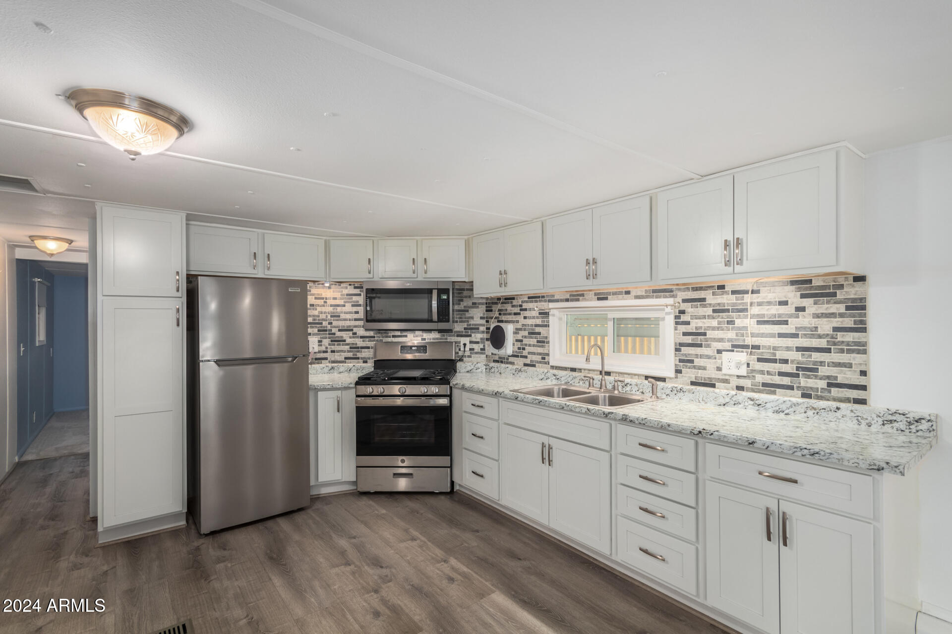 44 South Hawes Road, Unit A15 Mesa, AZ 85208 - Photo 14 of 40 a kitchen with stainless steel appliances granite countertop a stove a refrigerator and a sink