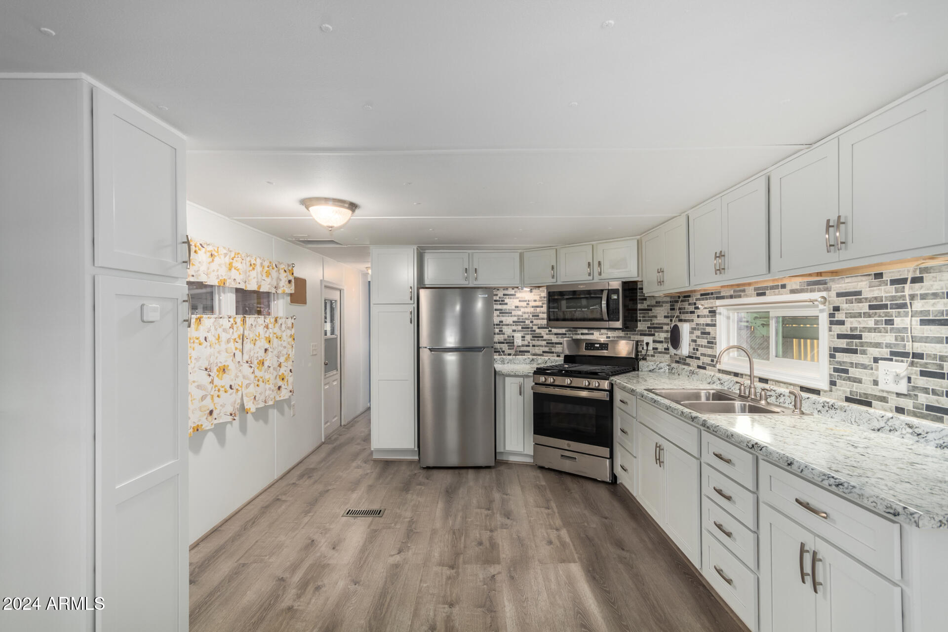 44 South Hawes Road, Unit A15 Mesa, AZ 85208 - Photo 15 of 40 a kitchen with stainless steel appliances granite countertop a refrigerator a stove and white cabinets