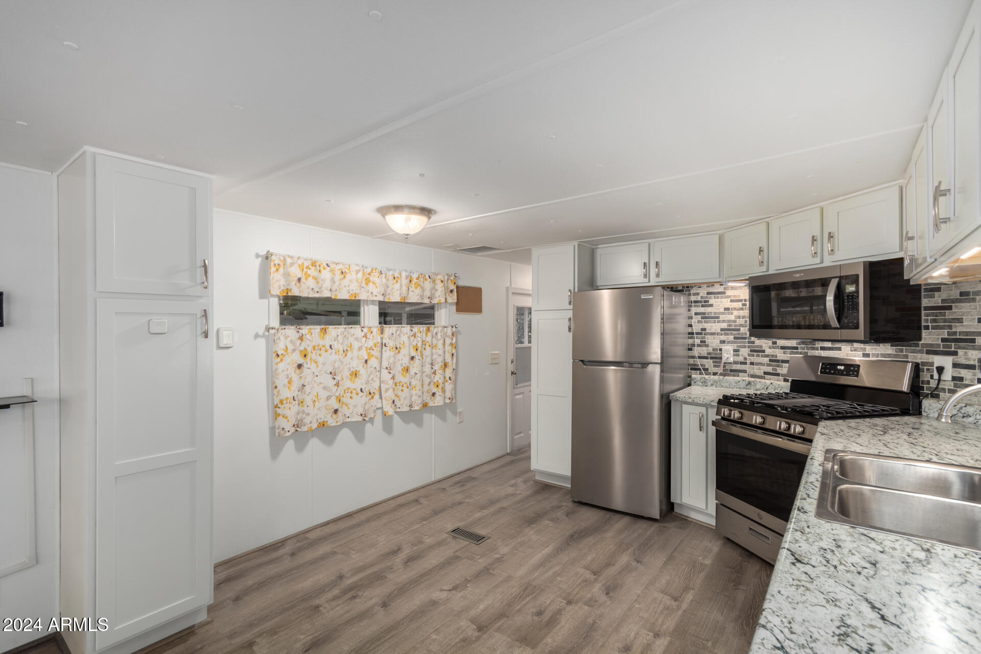 44 South Hawes Road, Unit A15 Mesa, AZ 85208 - Photo 16 of 40 a kitchen with stainless steel appliances a refrigerator and a stove top oven