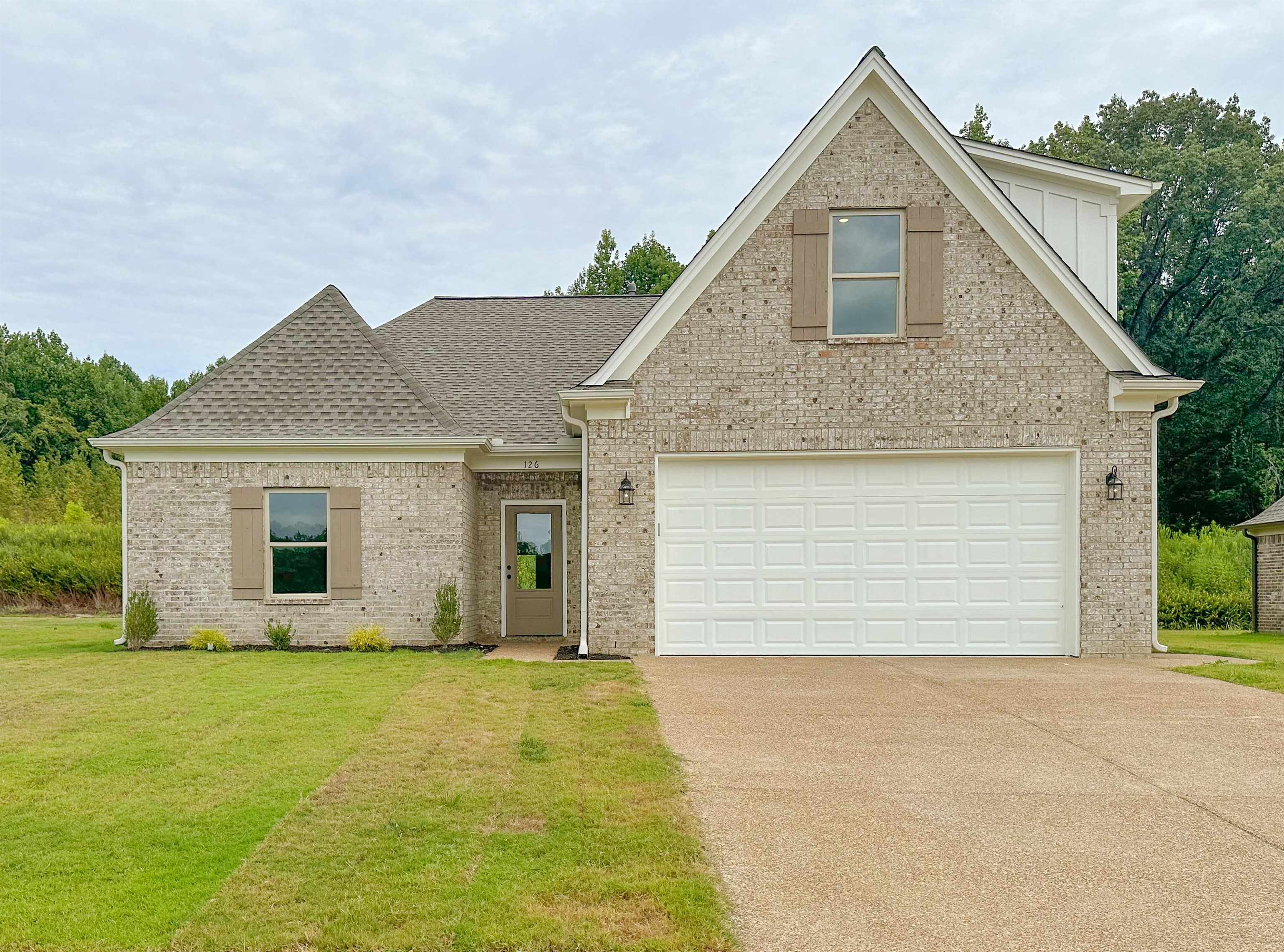 View of front facade featuring a garage and a front yard