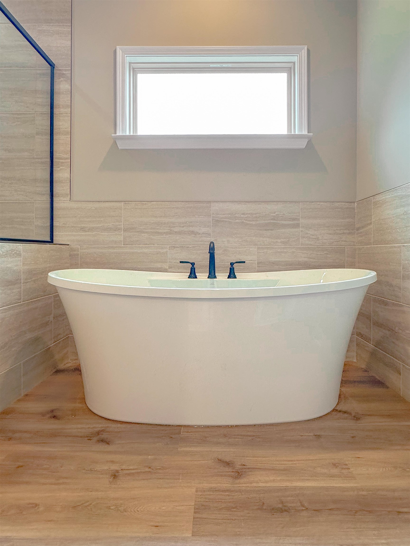 126 Stewart Road Munford, TN 38058 - Photo 16 of 23 Bathroom with tile walls, a tub to relax in, and a healthy amount of sunlight