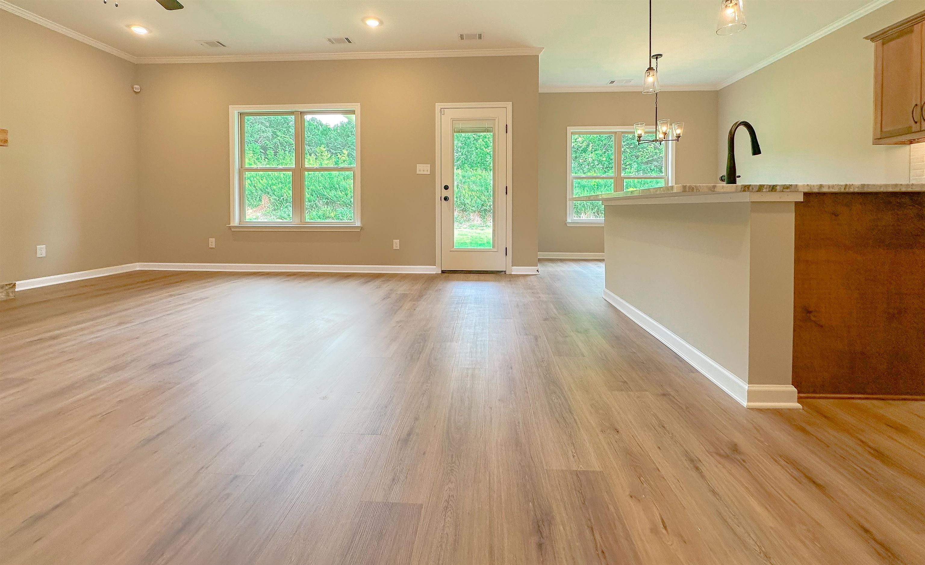 126 Stewart Road Munford, TN 38058 - Photo 5 of 23 Unfurnished living room featuring light wood-type flooring, a notable chandelier, and crown molding