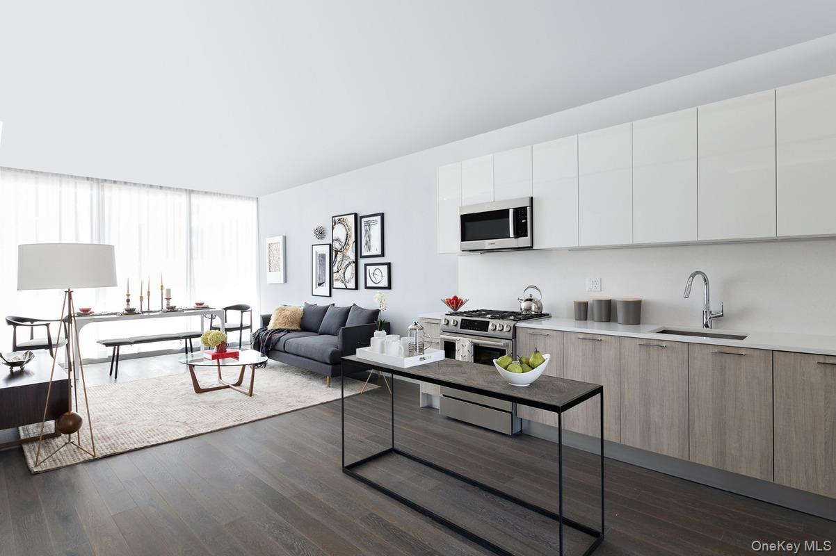 131-03 40 Road, Unit 11J Queens, NY 11354 - Photo 2 of 24 a living room with furniture and a wooden floor