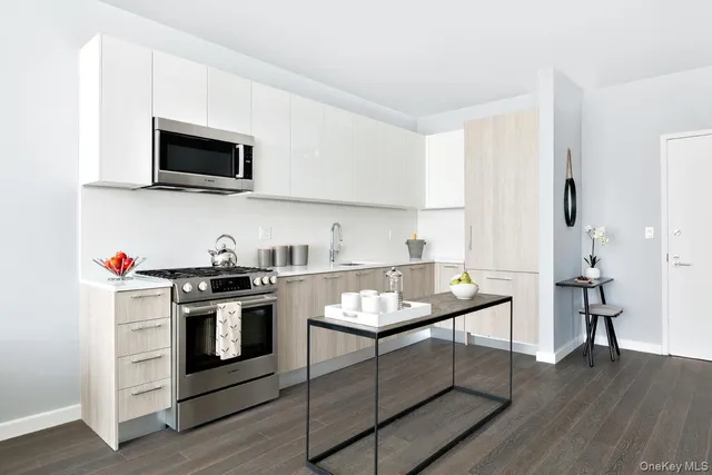 a kitchen with stainless steel appliances granite countertop a stove a sink and a microwave