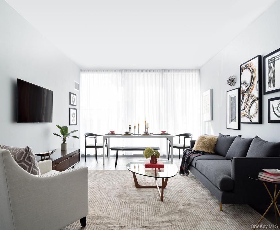 131-03 40 Road, Unit 11J Queens, NY 11354 - Photo 5 of 24 a living room with furniture and a flat screen tv