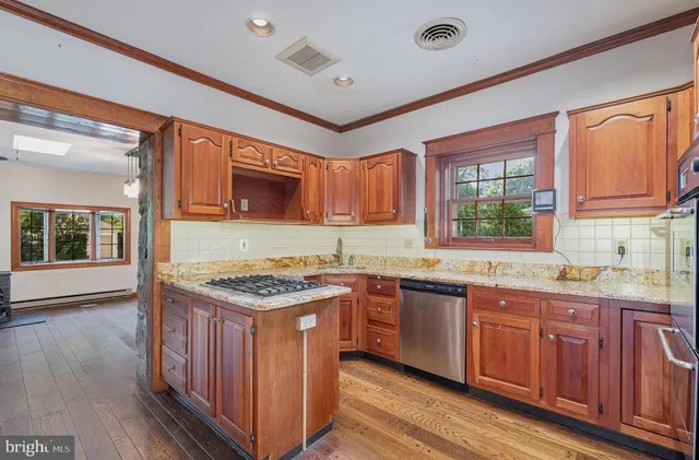 a kitchen with a stove top oven a sink and dishwasher with wooden cabinets