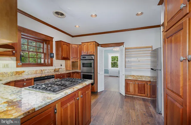 a kitchen with a refrigerator and a stove top oven