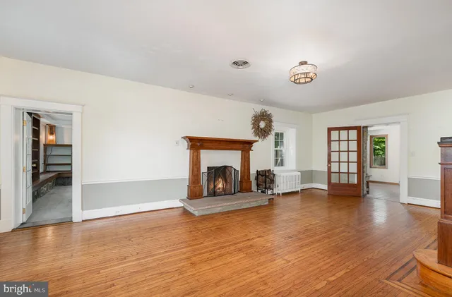 an empty room with wooden floor and a fireplace