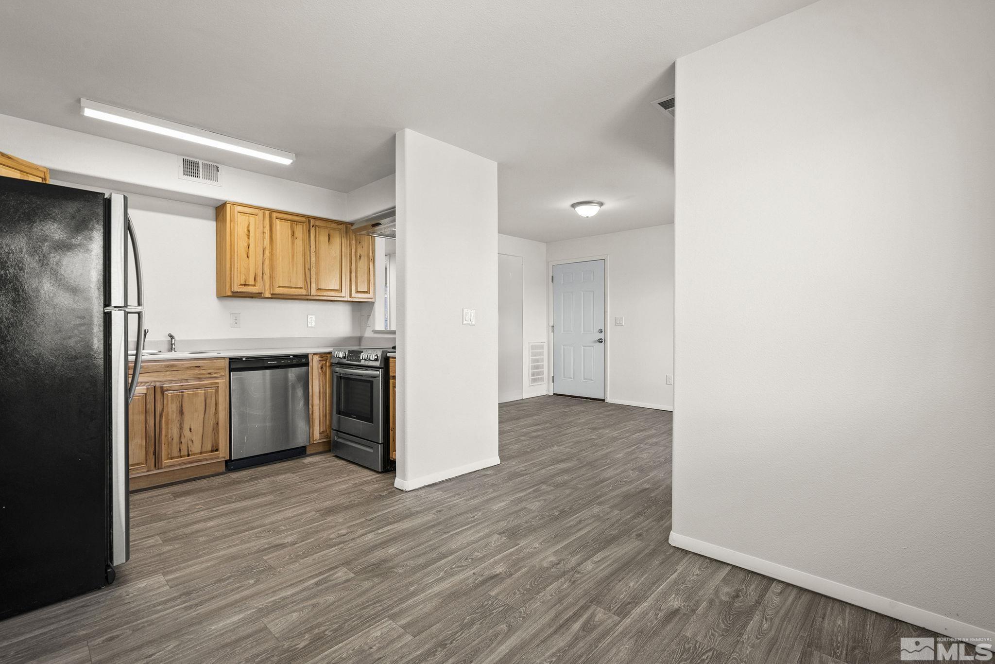 15 Gentry Way, Unit 12 Reno, NV 89502 - Photo 11 of 19 a kitchen with stainless steel appliances a refrigerator and a hard wood floor
