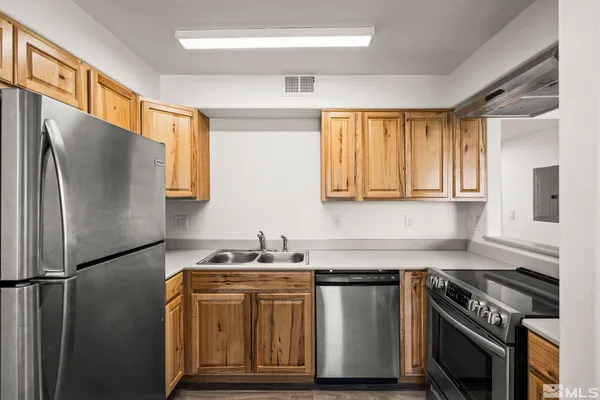 a kitchen with stainless steel appliances granite countertop a sink stove and refrigerator