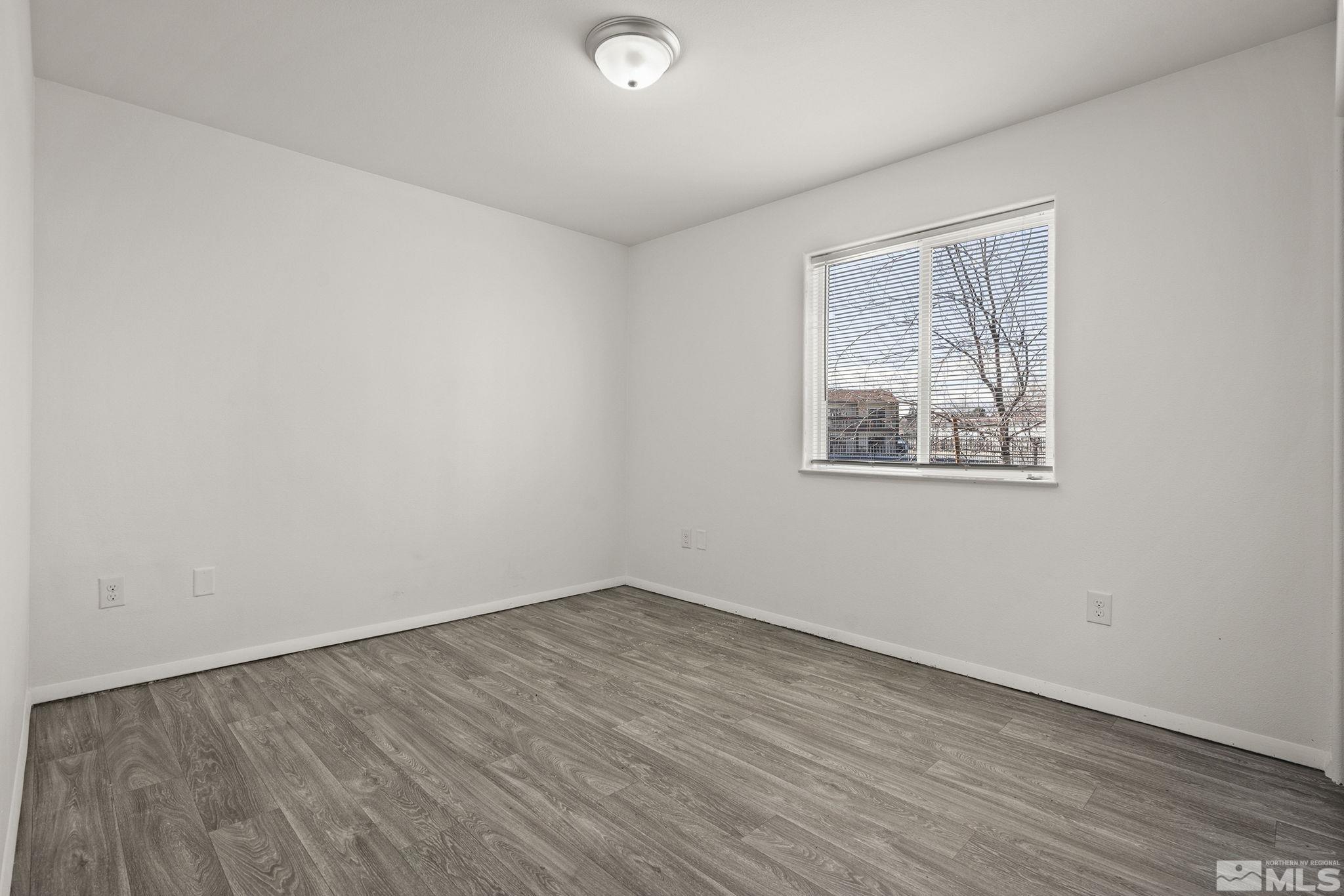15 Gentry Way, Unit 12 Reno, NV 89502 - Photo 18 of 19 an empty room with wooden floor and windows