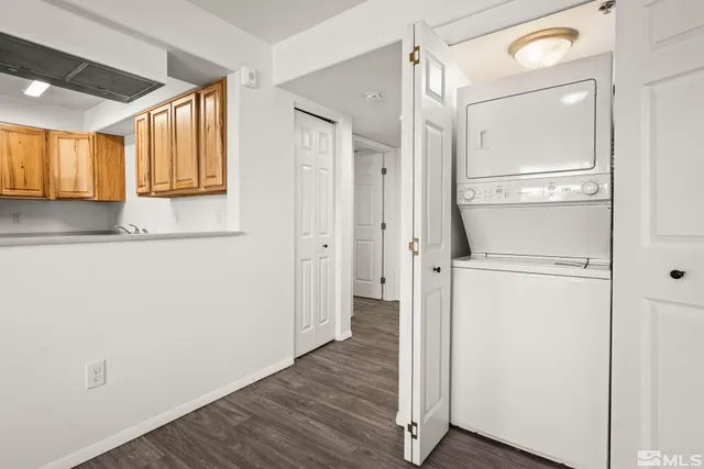 a view of a hallway with wooden floor and cabinet