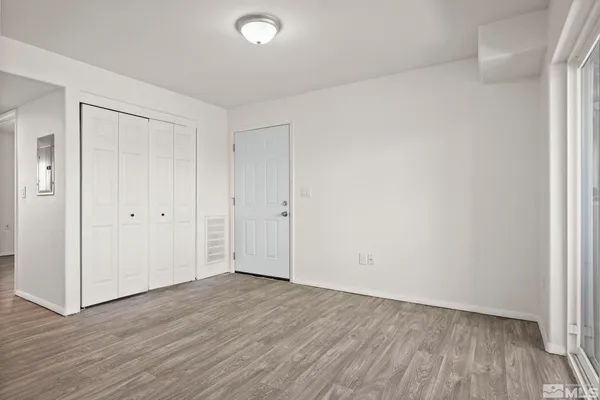 a view of an empty room with wooden floor