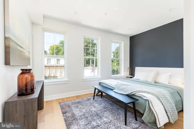 a bedroom with a bed and a chair next to a window