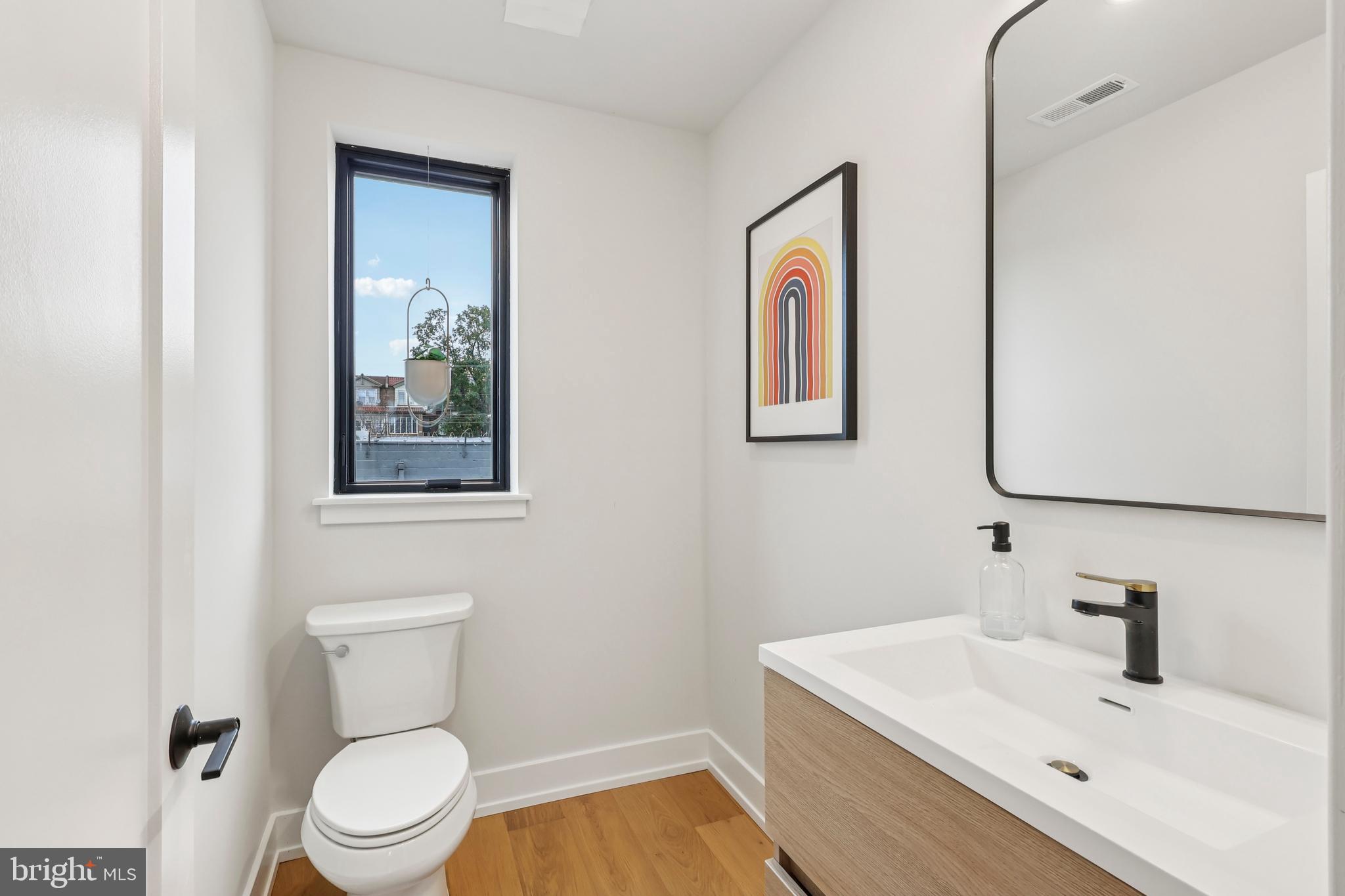 3843 Ridge Avenue Philadelphia, PA 19132 - Photo 19 of 33 a bathroom with a toilet a sink and mirror