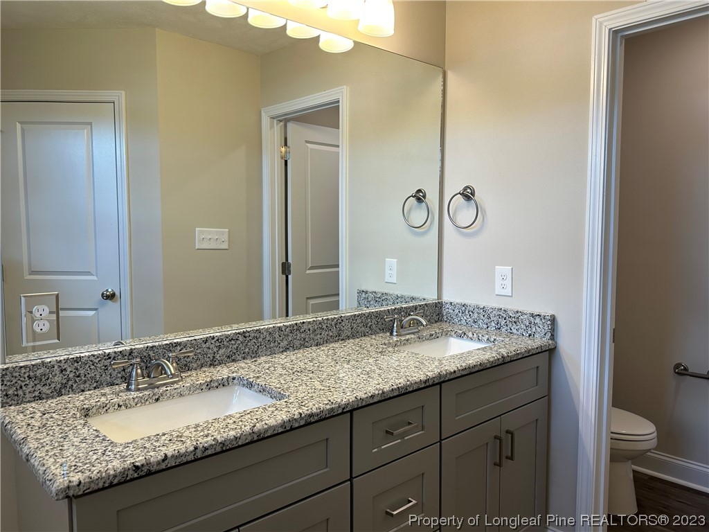 2526 Sand Hill Road Fayetteville, NC 28306 - Photo 32 of 40 a bathroom with a granite countertop sink and a mirror