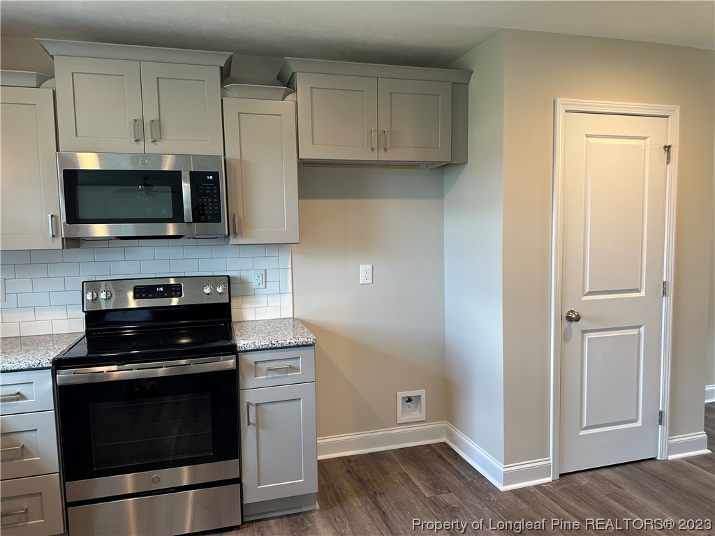 2526 Sand Hill Road Fayetteville, NC 28306 - Photo 7 of 40 a kitchen with cabinets stainless steel appliances and a wooden floor